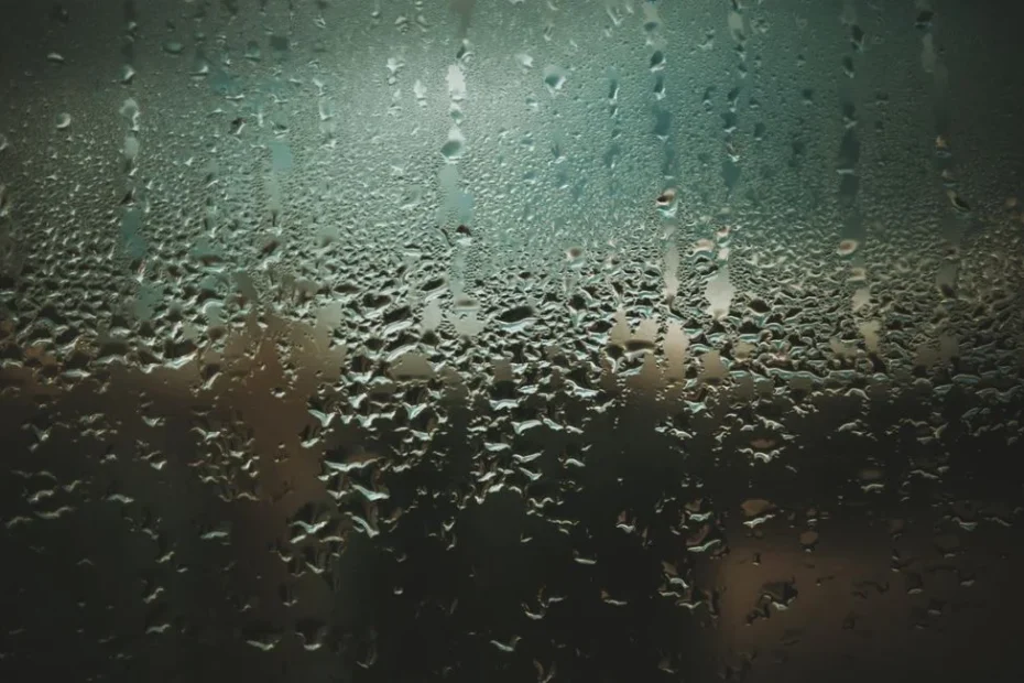Beschlagenes Fenster mit Wassertropfen im Wintermorgen Innenraum