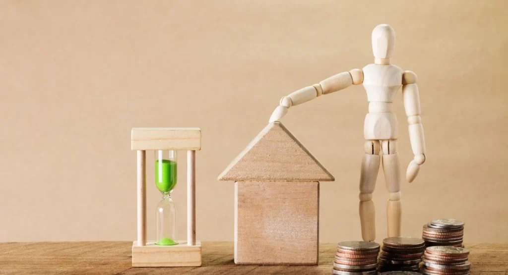 Familie vor einem Einfamilienhaus beim Budgetgespräch mit Unterlagen