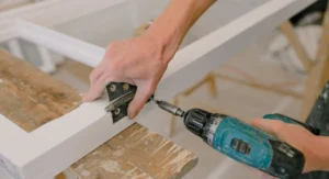 Handwerker baut altes Holzfenster in Altbau aus beim Sanieren