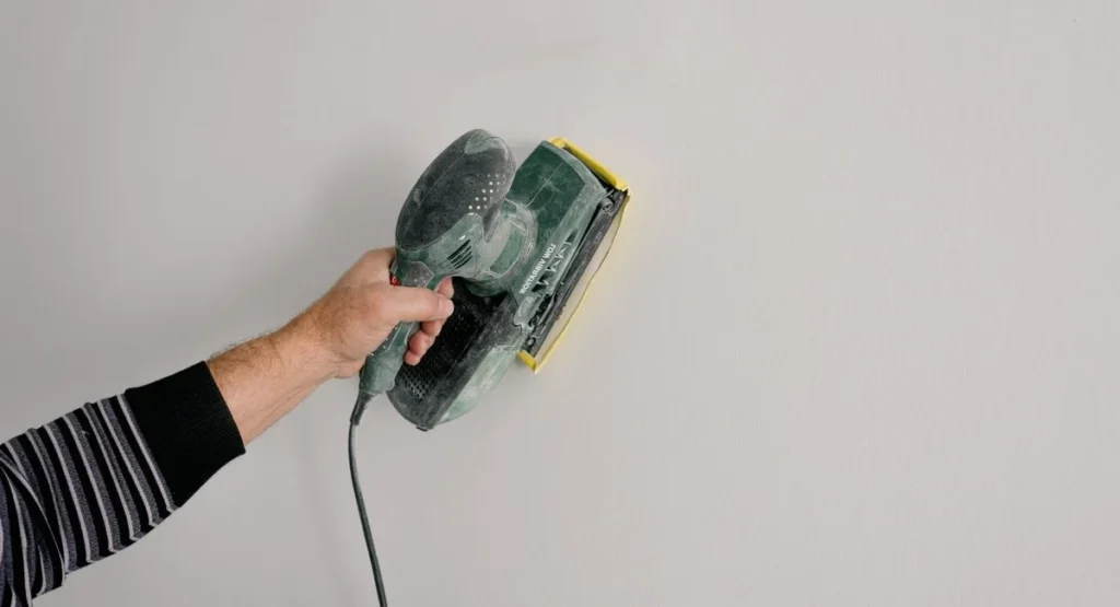 Handwerker dämmt Hausfassade bei energetischer Sanierung eines Altbaus