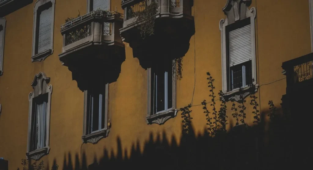Kleiner Stadtbalkon mit Pflanzen und Holzboden im Sommer