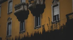 Kleiner Stadtbalkon mit Pflanzen und Holzboden im Sommer