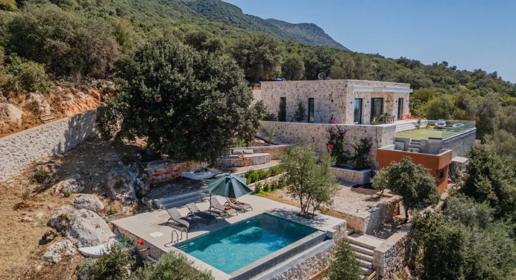 Moderner Garten mit rechteckigem Pool und Natursteintetrasse im Sonnenlicht